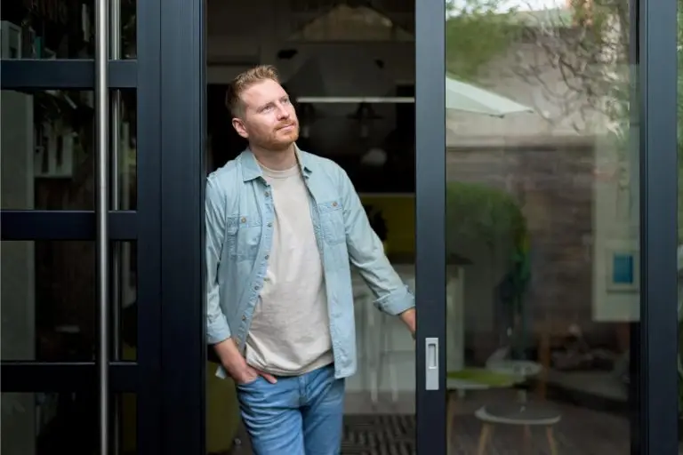 young adult bearded man, checking the weather outside, getting some fresh air.